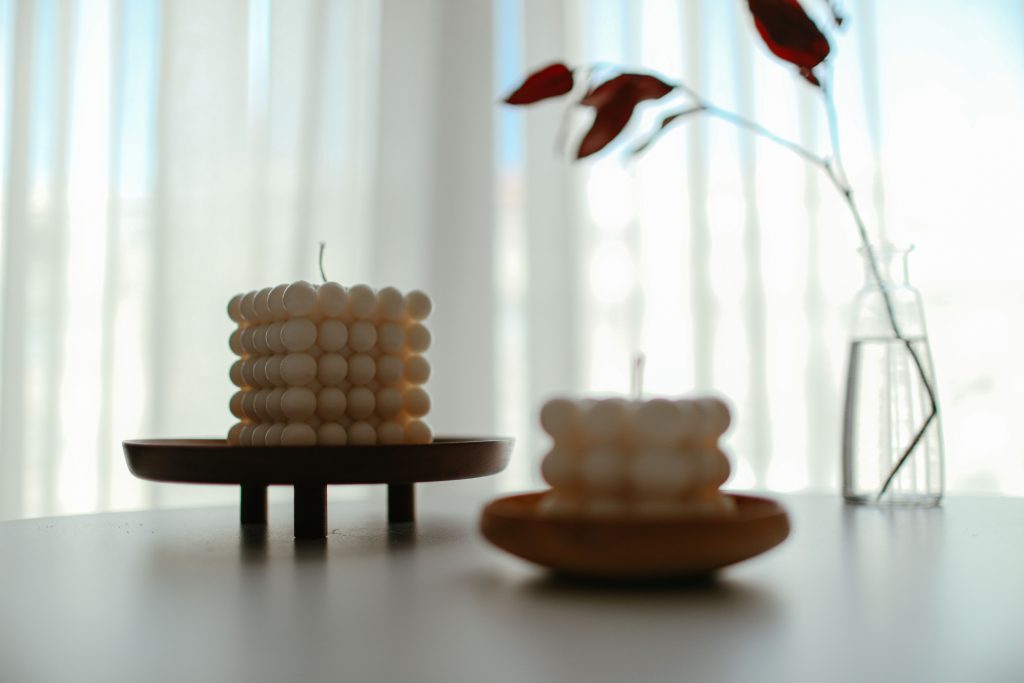Elegant minimalist decor featuring a cubed candle and leaf in a vase, perfect for modern interiors.